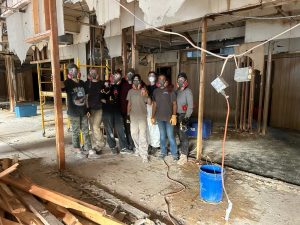 volunteer-group-tearing-out-rotted-walls